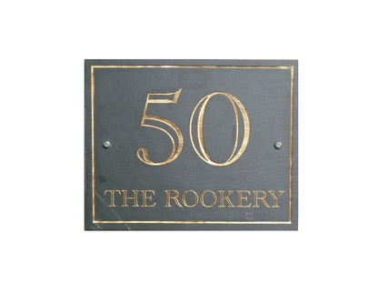 A rectangular Welsh slate house plaque laser engraved with a house number, house name and a border and colour filled in gold